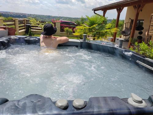 a woman in a jacuzzi tub in a backyard at Gímes Apartman in Cserszegtomaj