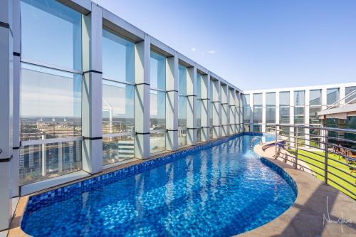 a large swimming pool in a building with windows at Nova stay Apart Moderno no Hotel Fusion in Brasilia