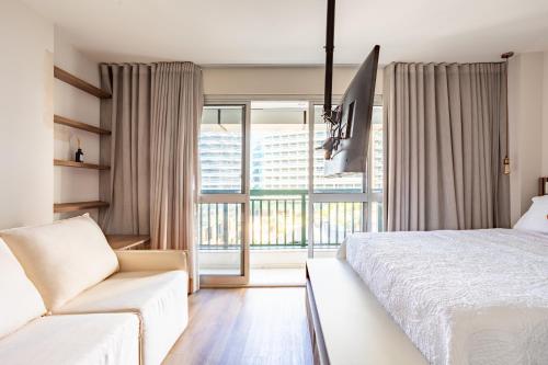a bedroom with a bed and a couch and a window at Nova stay Apart Moderno no Hotel Fusion in Brasilia