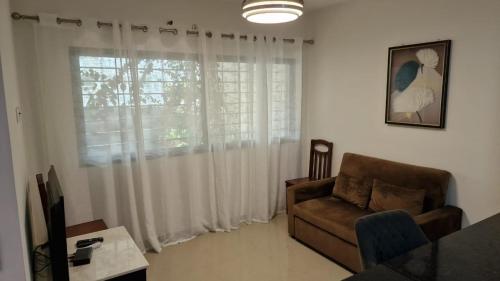 a living room with a couch and a window at SUITES-HOME, CIDADELA in Praia