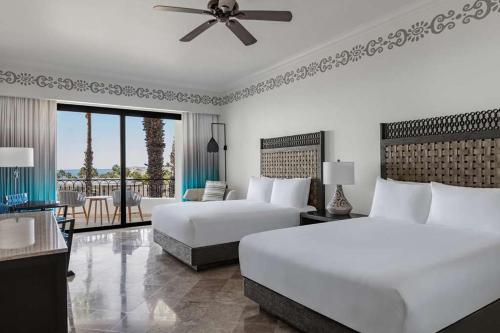 a hotel room with two beds and a balcony at Beach&Golf suites in El Bedito