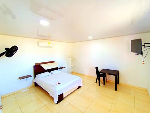 a bedroom with a bed and a chair and a desk at HOTEL y RESTAURANTE RANCHO GRANDE in Cicuco