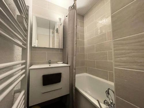 La petite salle de bains est pourvue d'un lavabo et d'une baignoire. dans l'établissement Résidence Arc En Ciel B - T2 tout confort avec vue et accès rapide aux pistes MAE-5151, à Vénosc