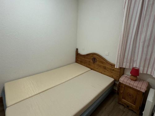 - un petit lit dans une petite chambre avec une lampe rouge dans l'établissement Appartement tout confort proche pistes avec balcon, WIFI, animaux admis - FR-1-181-2179, à La Plagne Tarentaise