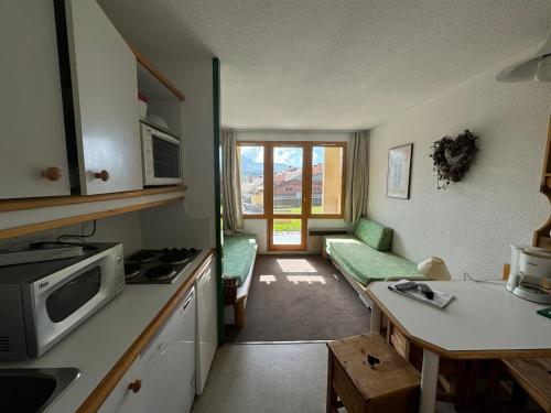 une cuisine et un salon avec un canapé et une table dans l'établissement Studio cosy avec balcon, accès direct aux pistes, Belle Plagne - FR-1-181-2222, à La Plagne Tarentaise