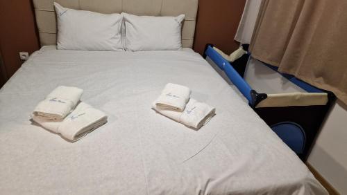 a bed with two towels sitting on top of it at LUXURY APARTMAN ELENI ROOMS oaza mira i tišine u centru Vrnjačke banje in Vrnjačka Banja
