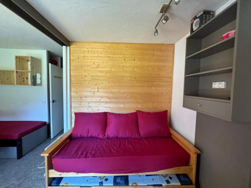 Cette chambre comprend un lit avec des oreillers roses. dans l'établissement Studio Rénové au Cœur de la Station avec Balcon et Parking - FR-1-181-2431, à La Plagne Tarentaise