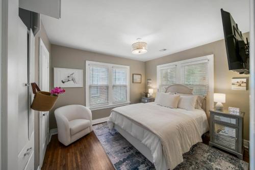 une chambre avec un lit et une chaise dans l'établissement Ivy Cottage W Hot Tub By Hvnlyhomes, à Tulsa