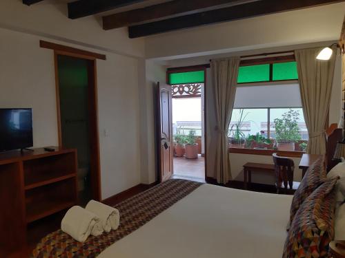a hotel room with a bed and a television at Hotel El Giro in Villa de Leyva