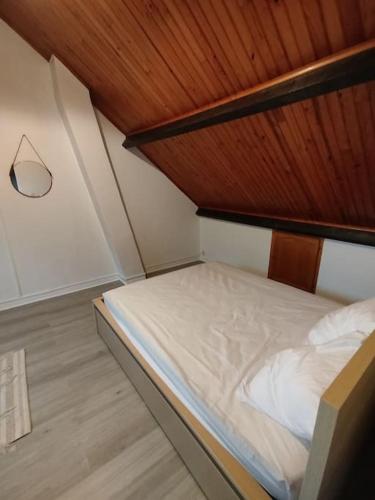 un lit dans une chambre avec un plafond en bois dans l'établissement Chambre privée appartement cosy, à Chelles