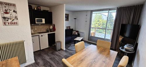 Il comprend un salon avec une table en bois et une cuisine. dans l'établissement Résidence Cote Brune 3 Bat 3-j4 - Studio Résidence COTE-BRUNE au pied-des-pistes MAE-5431, à Vénosc