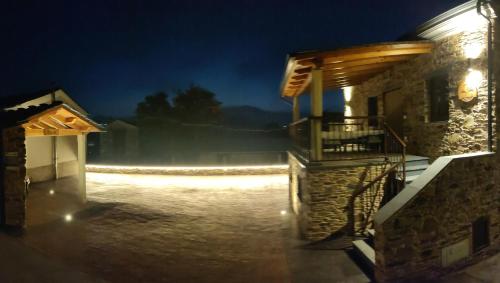 a stone building with a porch at night at Apartamentos Rurales Torre de la Alcandra - 3 llaves - Asturias in Vegadeo