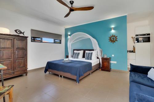 a bedroom with a bed and a blue wall at Deluxe Boutique Apartments Sonrisa - Adults only in Kralendijk