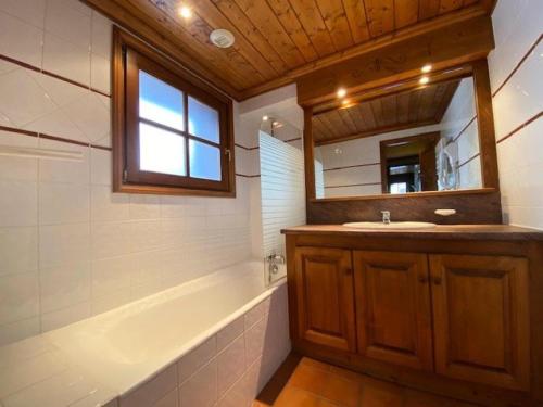 une salle de bain avec une baignoire, un lavabo et un miroir dans l'établissement Résidence Alpina Lodge - Jolie T3 au pied des pistes et commerces MAE-5631, à Vénosc