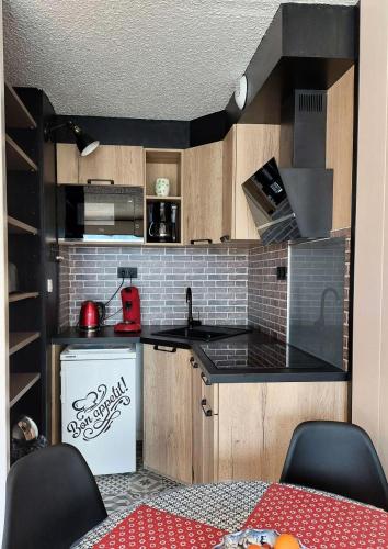 Il comprend une petite cuisine équipée d'une cuisinière et d'un réfrigérateur. dans l'établissement Résidence Diamant 1 - Studio exposé plein sud avec une vue imprenable sur la montagne MAE-5621, à Vénosc