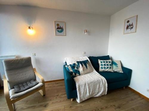 un salon avec un canapé bleu et une chaise dans l'établissement Résidence Soleil - Appartement contemporain avec vue spectaculaire dans un secteur calme MAE-5641, à Vénosc