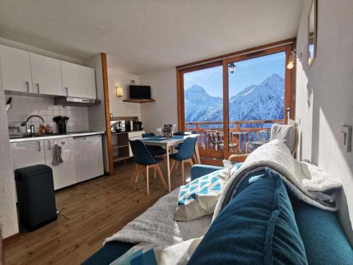 Il comprend une cuisine et un salon offrant une vue sur la montagne. dans l'établissement Résidence Soleil - Appartement contemporain avec vue spectaculaire dans un secteur calme MAE-5641, à Vénosc