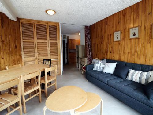 un salon avec un canapé bleu et une table dans l'établissement Appartement lumineux 3 pièces, skis aux pieds, 10 pers, balcon, proche commerces et pistes - FR-1-502-362, à Tignes