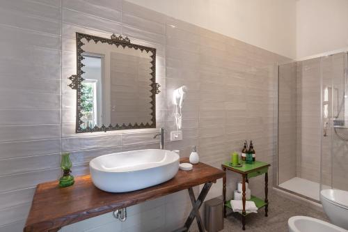 Un baño con bañera, lavabo y espejo. en Palazzo Desiderio, en Castellammare di Stabia