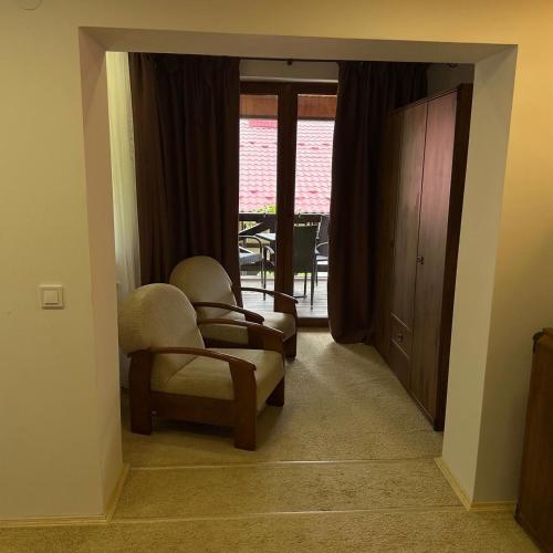 a living room with two chairs and a window at GORGANY resort & SPA in Yablunytsya