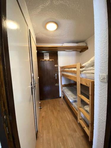 Cette chambre comprend 2 lits superposés et une porte. dans l'établissement Résidence Kandahar - Agréable studio au centre de la station MAE-5691, à Vénosc