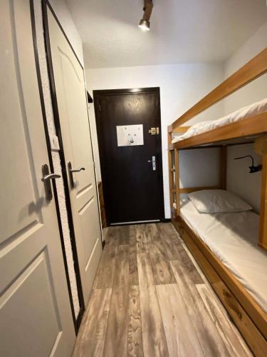 Cette petite chambre comprend des lits superposés et une porte. dans l'établissement Résidence Kandahar - Agréable appartement esprit montagne, en centre station MAE-5701, à Vénosc