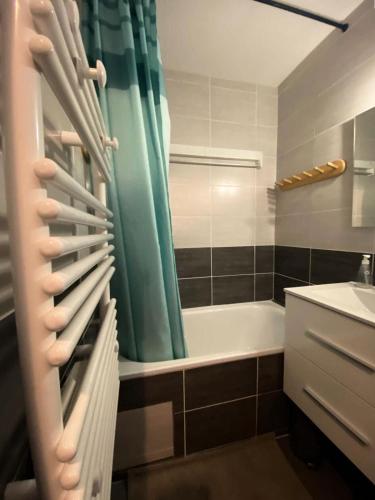 une salle de bain avec un rideau de douche vert et une baignoire dans l'établissement Résidence Kandahar - Agréable appartement esprit montagne, en centre station MAE-5701, à Vénosc