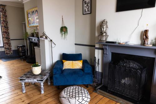 a living room with a blue chair and a fireplace at CloudZen in Kent