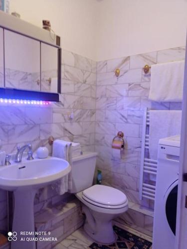 une salle de bain avec des toilettes blanches et un lavabo dans l'établissement Appartement cœur de paris, à Paris