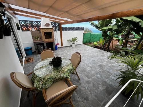 a patio with a table and chairs and a fireplace at Casa El Lagar in La Guancha