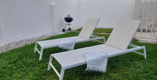 two white chairs sitting on the grass next to a camera at MINZONI94 - TwoBedroom+Garden in Lido di Camaiore