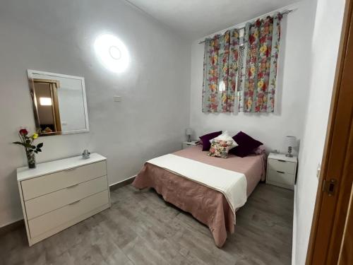 a small bedroom with a bed and a mirror at Casa El Lagar in La Guancha