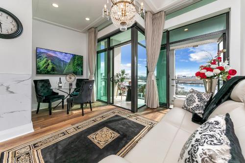 a living room with a white couch and a table and chairs at Penthouse Glory in Auckland