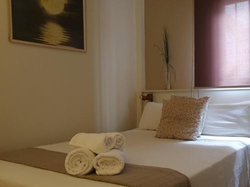 une chambre d'hôtel avec un lit avec des serviettes dessus dans l'établissement LUNA-Guest Rooms, à Alcalá de Guadaira