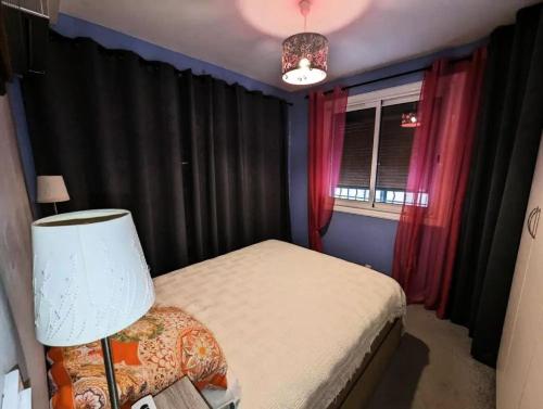 une chambre avec un lit, une lampe et une fenêtre dans l'établissement Résidence Embruns - Appartement 4 couchages avec belle terrasse à deux pas de la mer MAE-4631, à Six-Fours-les-Plages