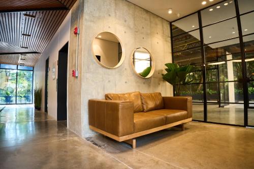 a brown leather couch in a lobby with a mirror at HYPE STATES Cali in El Peñón