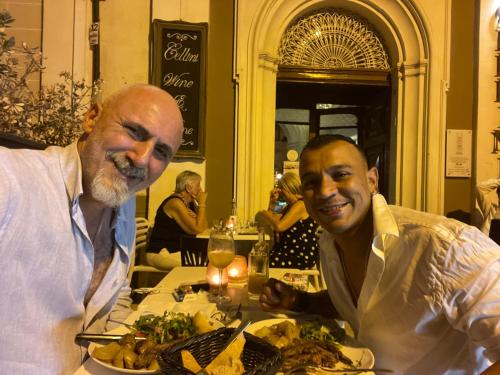 two men sitting at a table with a plate of food at No 7 Casa Nannakola in Naxxar