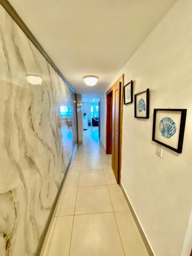 a hallway in a building with a marble wall at LasOlasTower JuanDolio-2Br-3Bds-7Px-WiFi-SeaView in Juan Dolio