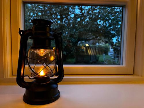 a lantern sitting on a table in front of a window at Elbkoje in Drage