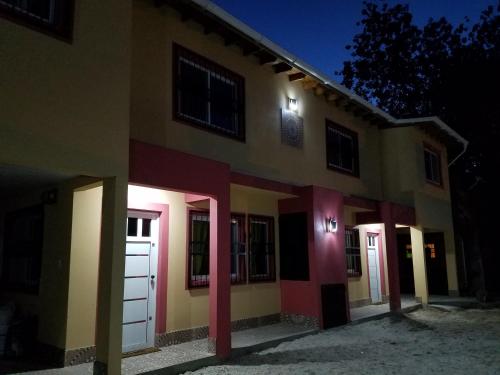 a building with a bunch of doors on it at night at Arbolada Talas del Tuyu in San Clemente del Tuyú