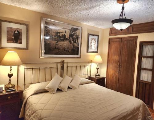 a bedroom with a large white bed with two lamps at El Meson de los Poetas in Guanajuato