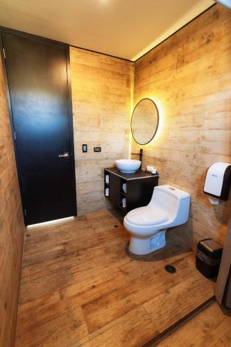 a bathroom with a toilet and a sink and a mirror at Awqa Loft & Camp in Trujillo