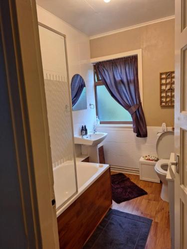 a bathroom with a tub and a sink at Twin Deer Lodge in Glenfinnan
