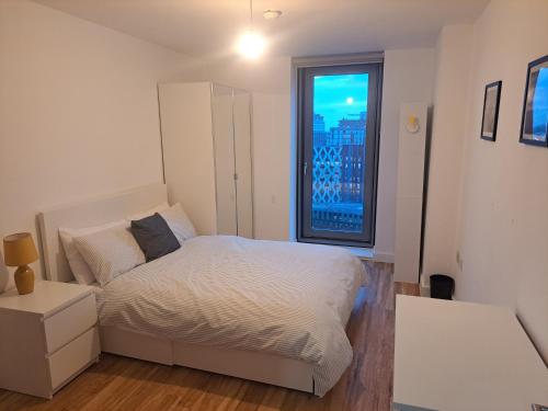 a bedroom with a white bed and a window at Media City Apartment Manchester in Manchester