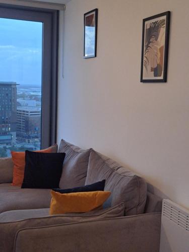 a living room with a couch and a large window at Media City Apartment Manchester in Manchester