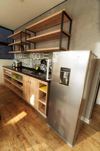 a kitchen with a stainless steel refrigerator and wooden floors at Awqa Loft & Camp in Trujillo