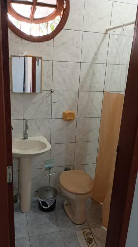 a bathroom with a toilet and a sink at Cantinho da Lu em Santa Mônica in Guarapari