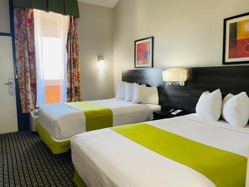 a hotel room with two beds and a window at SureStay by Best Western Irving Grapevine DFW North in Irving