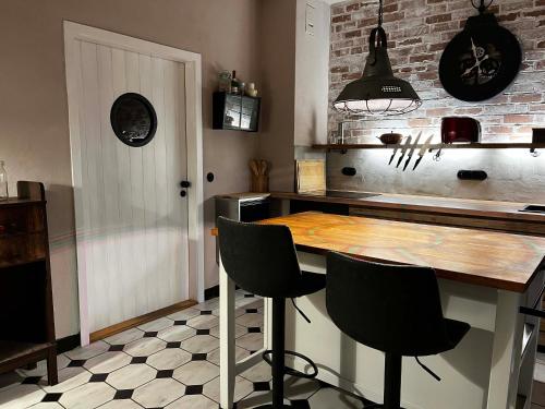 a kitchen with a wooden counter and black chairs at Elbkoje in Drage