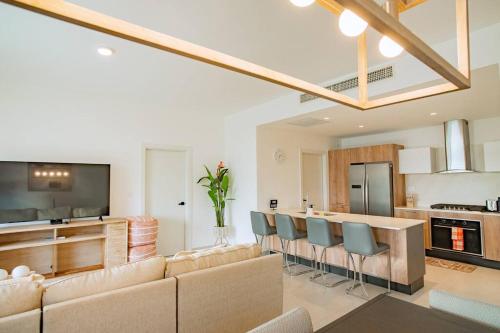 a living room with a couch and a kitchen at Luxury Retreat Condo 3BR Pool & Spa Azzure-Cap Cana in Punta Cana